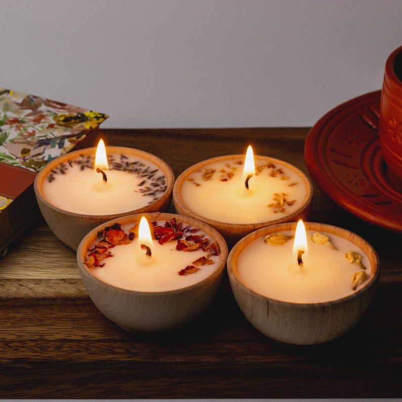Set of four one ounce aromatherapy candles in a wooden cup reusable eco friendly sustainable pure soy and essential oil candle lavender eucalyptus orange grapefruit rosemary palmarosa essential oils and custom oil blends for calm gift relax spa gift Set of four essential oil soy tealight candles from Megan’s Pantry in reusable wooden bowls, adorned with botanicals—natural, eco-friendly aromatherapy gift set.