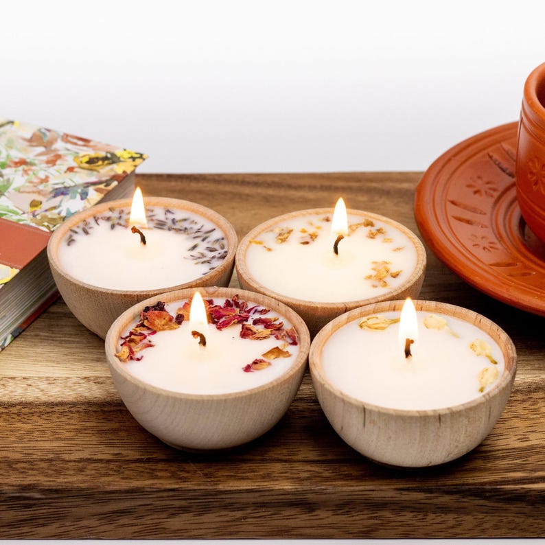 Set of four one ounce aromatherapy candles in a wooden cup reusable eco friendly sustainable pure soy and essential oil candle lavender eucalyptus orange grapefruit rosemary palmarosa essential oils and custom oil blends for calm gift relax spa gift Set of four essential oil soy tealight candles from Megan’s Pantry in reusable wooden bowls, adorned with botanicals—natural, eco-friendly aromatherapy gift set.