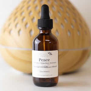 May include: A 2-ounce (60 ml) amber glass bottle of essential oil diffuser blend labeled "Peace" with the ingredients grapefruit and rosemary. The bottle has a black dropper cap and a white label with the brand name "Vegan Pantry".