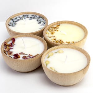 Set of four one ounce aromatherapy candles in a wooden cup reusable eco friendly sustainable pure soy and essential oil candle lavender eucalyptus orange grapefruit rosemary palmarosa essential oils and custom oil blends for calm gift relax spa gift Set of four essential oil soy tealight candles from Megan’s Pantry in reusable wooden bowls, adorned with botanicals—natural, eco-friendly aromatherapy gift set.