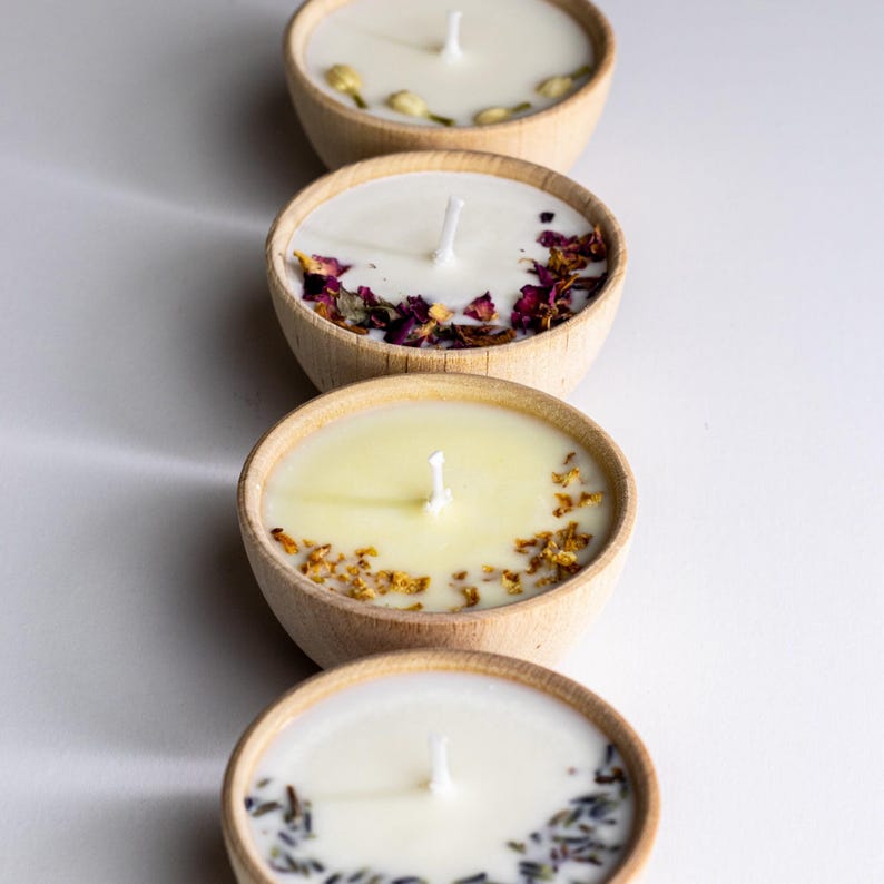 Set of four one ounce aromatherapy candles in a wooden cup reusable eco friendly sustainable pure soy and essential oil candle lavender eucalyptus orange grapefruit rosemary palmarosa essential oils and custom oil blends for calm gift relax spa gift Set of four essential oil soy tealight candles from Megan’s Pantry in reusable wooden bowls, adorned with botanicals—natural, eco-friendly aromatherapy gift set.