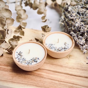 Set of four one ounce aromatherapy candles in a wooden cup reusable eco friendly sustainable pure soy and essential oil candle lavender eucalyptus orange grapefruit rosemary palmarosa essential oils and custom oil blends for calm gift relax spa gift Set of four essential oil soy tealight candles from Megan’s Pantry in reusable wooden bowls, adorned with botanicals—natural, eco-friendly aromatherapy gift set.