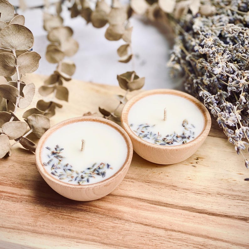 Set of four one ounce aromatherapy candles in a wooden cup reusable eco friendly sustainable pure soy and essential oil candle lavender eucalyptus orange grapefruit rosemary palmarosa essential oils and custom oil blends for calm gift relax spa gift Set of four essential oil soy tealight candles from Megan’s Pantry in reusable wooden bowls, adorned with botanicals—natural, eco-friendly aromatherapy gift set.