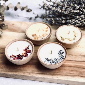 Set of four one ounce aromatherapy candles in a wooden cup reusable eco friendly sustainable pure soy and essential oil candle lavender eucalyptus orange grapefruit rosemary palmarosa essential oils and custom oil blends for calm gift relax spa gift Set of four essential oil soy tealight candles from Megan’s Pantry in reusable wooden bowls, adorned with botanicals—natural, eco-friendly aromatherapy gift set.