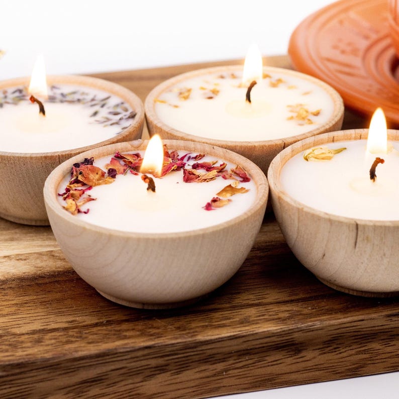 Set of four one ounce aromatherapy candles in a wooden cup reusable eco friendly sustainable pure soy and essential oil candle lavender eucalyptus orange grapefruit rosemary palmarosa essential oils and custom oil blends for calm gift relax spa gift Set of four essential oil soy tealight candles from Megan’s Pantry in reusable wooden bowls, adorned with botanicals—natural, eco-friendly aromatherapy gift set.