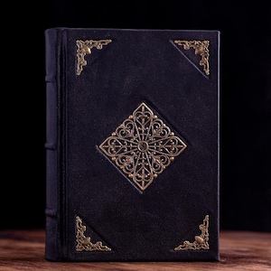 Skuggornas bok, läderinbunden grimoirejournal med tomma sidor och dekorerad framsida