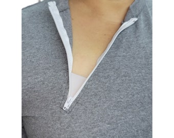 May include: A gray long-sleeved shirt with a white zipper down the front.