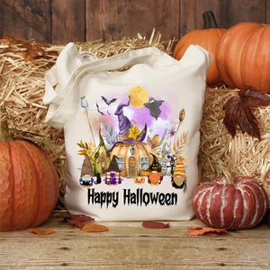 Pu&ograve; includere: Una borsa tote in tela bianca con un design a tema Halloween. Il design presenta una casa a forma di zucca con un cappello da strega, gnomi e il testo "Happy Halloween".