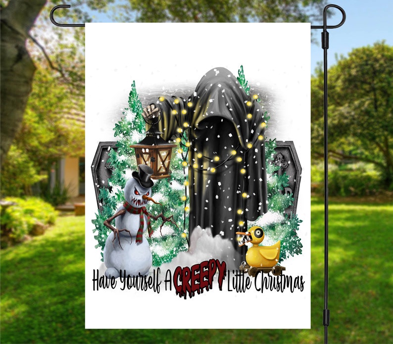 Op de afbeelding: Een witte tuin vlag met een zwarte gekapte figuur, een sneeuwpop met een dreigende grijns, een gele rubberen eend en een lantaarn. De tekst luidt "Have Yourself A Creepy Little Christmas".