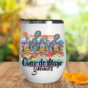 May include: White stainless steel wine tumbler with a colorful design of gnomes wearing sombreros and cacti. The text "Cinco de Mayo Gnomes" is printed on the tumbler.