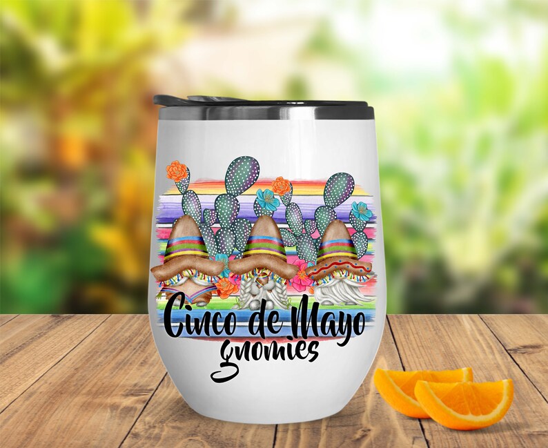 May include: White stainless steel wine tumbler with a colorful design of gnomes wearing sombreros and cacti. The text "Cinco de Mayo Gnomes" is printed on the tumbler.