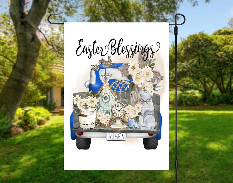 Peut inclure: Un camion vintage bleu avec une benne en bois remplie de d&eacute;corations de P&acirc;ques. Le camion a une plaque blanche qui dit "Risen" et les mots "Easter Blessings" sont &eacute;crits en blanc sur un fond blanc.