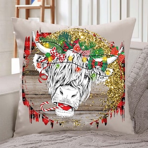 May include: A white and black Highland cow with a red and green tartan background. The cow is wearing a Christmas wreath with red bows and lights. The background is a rustic wood texture with gold glitter.