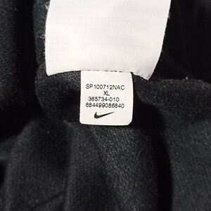 Puede incluir: Una etiqueta blanca con texto negro y un logotipo Nike swoosh. La etiqueta dice "SP100712NAC XL 365734-010 884499086840".