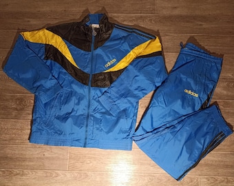 Conjunto deportivo vintage adidas de los 90 para hombre, en negro, azul y amarillo. Incluye chaqueta, pantalón y sudadera de punto. Talla M/L (GB/UK 40/42).