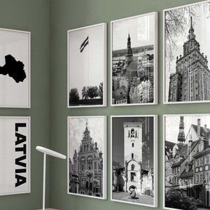 Peut inclure: Un ensemble de huit cadres muraux présentant des photographies en noir et blanc de l'architecture lettone, une carte de la Lettonie et le texte LATVIA en police sans empattement verticale, le tout dans des cadres blancs fins sur un mur vert.