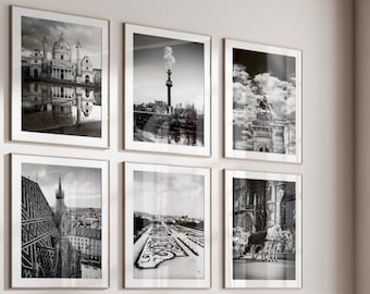 May include: A living room with a sectional sofa, a coffee table, and an armchair. The walls are decorated with black and white framed photographs of cityscapes.