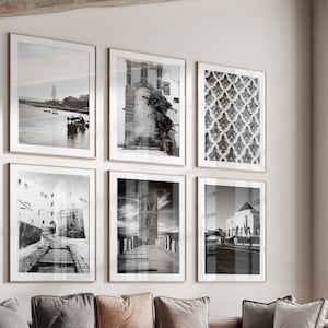 Puede incluir: Un salón moderno con un sofá seccional, una mesa de café y un sillón. La habitación está decorada con fotografías enmarcadas en blanco y negro de arquitectura y paisajes urbanos marroquíes.