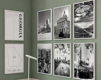 Puede incluir: Un conjunto de ocho láminas en blanco y negro con marcos blancos que muestran monumentos de Georgia, paisajes urbanos y un mapa del estado. Están expuestas en una pared verde sobre un escritorio blanco de tres cajones con una lámpara.