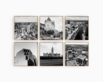 Könnte beinhalten: Ein Set aus sechs quadratischen, schwarz-weißen Wandbildern mit Rahmen, die Luft- und Architekturaufnahmen einer Stadt zeigen, darunter ein großes historisches Steingebäude mit einem zentralen Turm, ein moderner Glaswolkenkratzer und Stadtlandschaften.