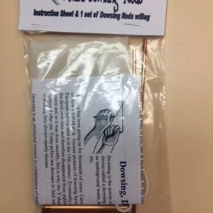 May include: A set of mini dowsing rods in a clear plastic bag with instructions. The rods are made of copper and are about 10 inches long. The instructions include information about the history of dowsing and how to use the rods.
