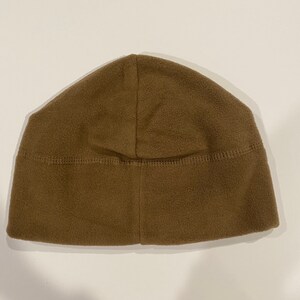 Puede incluir: Un gorro de lana marr&oacute;n. El gorro est&aacute; hecho de un material suave y c&aacute;lido y tiene un dise&ntilde;o sencillo.