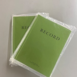 May include: Two green RECORD notebooks wrapped in plastic. The notebooks have the word "RECORD" printed on the front in black. The bottom of the notebook has the text "740-00-102-8115 FEDERAL SUPPLY SERVICE" printed in black.