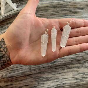 May include: Three white selenite crystal points wrapped in silver wire, each with a loop at the top for hanging.