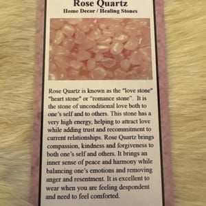 May include: A card with the text "Rose Quartz Home Decor / Healing Stones" and a photo of pink rose quartz stones. The card also includes text describing the properties of rose quartz, known as the "love stone".