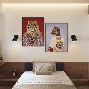 May include: Two framed illustrations of tigers. The first illustration features a tiger wearing a patterned jacket. The second illustration features a tiger wearing a white sweater with the word "GUCCI" and a tiger graphic.