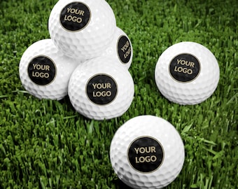 Può includere: Palline da golf bianche con la scritta "YOUR LOGO" in un cerchio nero. Le palline da golf sono disposte su erba verde. Le palline da golf hanno una superficie a fossette.
