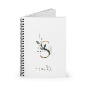 May include: A white spiral notebook with a gold and green watercolor letter S with leaves and gold dots. The name "scarlett" is written in cursive below the letter.