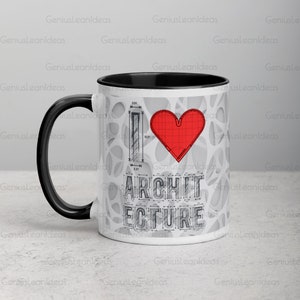 May include: A white ceramic coffee mug with a black rim and handle. The mug has a gray and white architectural design with a red heart and the text "I love architecture".