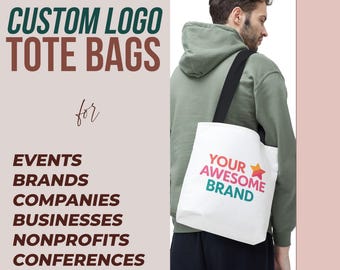 May include: A white tote bag with black handles and a colorful logo that says "YOUR AWESOME BRAND" with a star. The bag is being held by a person wearing a green hoodie.