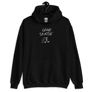 May include: Black hooded sweatshirt with a front pocket. The white text "GONE SKATIN'" is above a stick figure on roller skates. The sweatshirt has a drawstring hood and long sleeves.