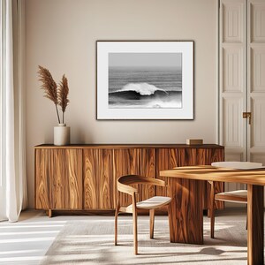 Minimalist surf photo in black and white tones, displayed in a Japandi-inspired living room with natural wood and soft textures. A quiet yet powerful statement piece, blending movement, nature, and balance. Digital download photography print.