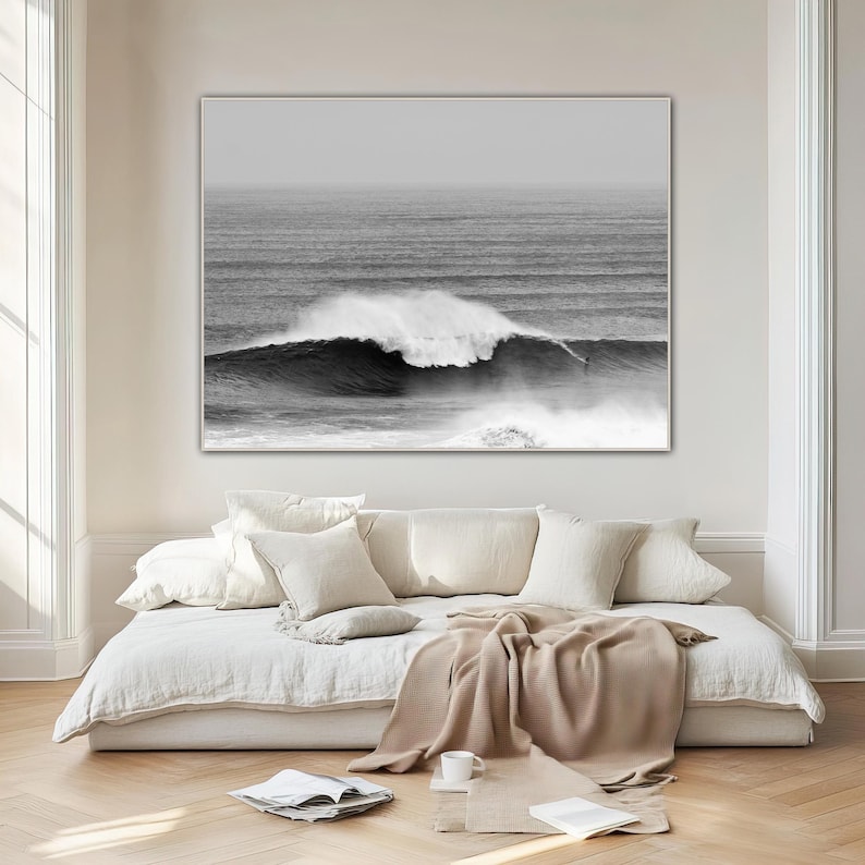 Minimalist surf photo in black and white tones, displayed in a soft minimalist bedroom with light colors and soft textures. A quiet yet powerful statement piece, blending movement, nature, and balance. Digital download photography print.