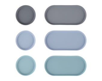 May include: Set of six round and oval trays in three colors: gray, light blue, and teal. The trays are made of a smooth, durable material and are perfect for serving snacks, drinks, or organizing small items.