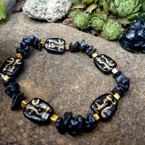 Glass blown creepy face and lava stone bracelet, crystal bracelet, gold accent face bracelet, black and gold bracelet, weird heads bracelet