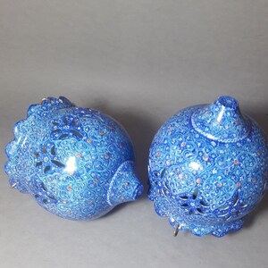 May include: Two blue and white ceramic hanging lamps with intricate floral patterns and cut-out designs.