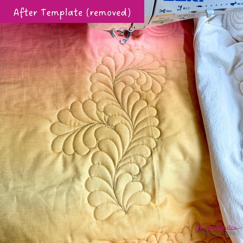 May include: A close-up of a quilt in progress, featuring a detailed feather design stitched in a golden thread. The fabric has a gradient of colors, transitioning from pink to yellow. The text "After Template (removed)" is visible.