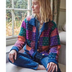 May include: A colorful patchwork cardigan with a button closure. The cardigan is made of a soft, textured yarn and features a variety of colors, including pink, purple, green, orange, and blue.