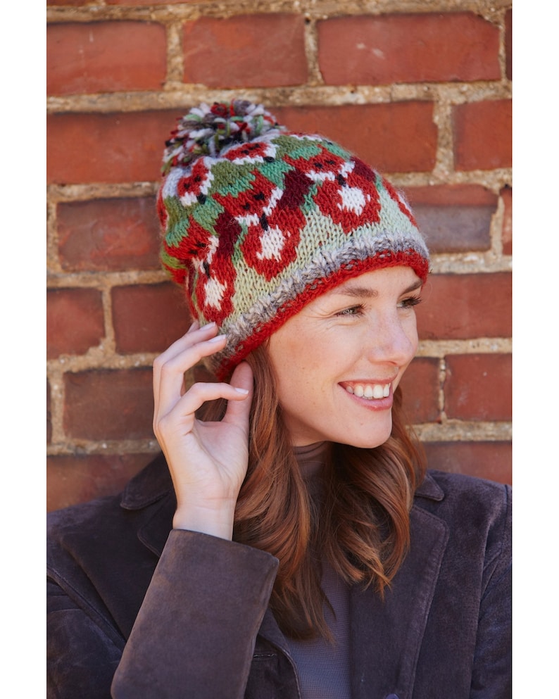 Hand knitted 100% sheep wool knitted bobble beanie. Orange foxes on a green, red and grey background. Stocking stitch with rib hem. Fleece lined around the forehead.
