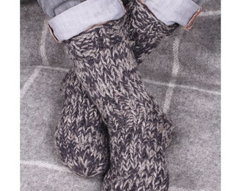 Puede incluir: Un par de calcetines gruesos de punto grueso en una combinación de gris oscuro y gris claro. Los calcetines están hechos de un material suave y cálido y son perfectos para mantener los pies calientes en invierno.
