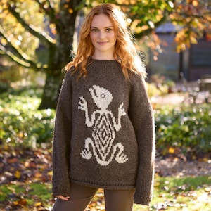 May include: A brown knitted jumper with a white lizard design. The jumper has a crew neck and long sleeves.