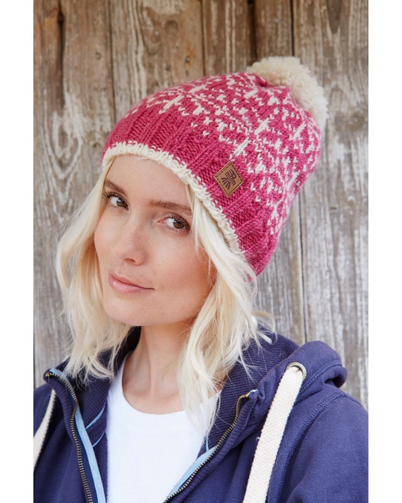 Mujer en la nieve con gorro blanco y jersey de lana azul. Stock Photo