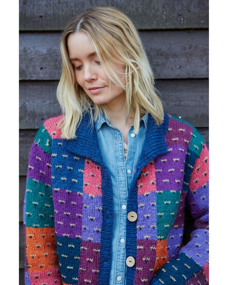 May include: A colorful patchwork cardigan with a blue background and a variety of colors including purple, green, orange, and pink. The cardigan has a button closure and a collar.