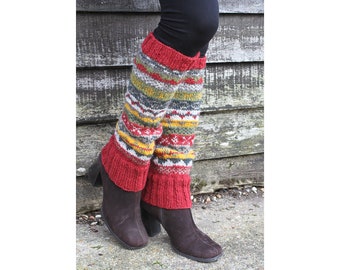 May include: Red, yellow, green and white striped leg warmers with a geometric pattern. The leg warmers are worn over brown boots.