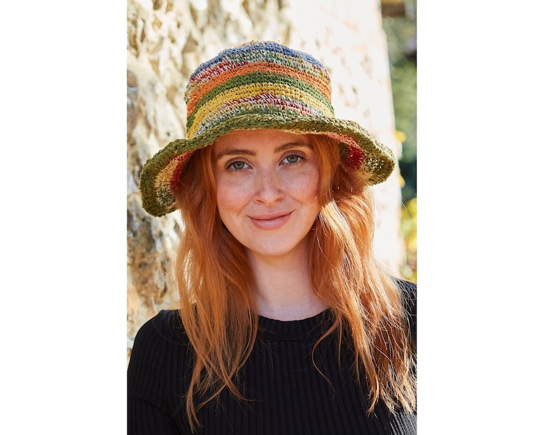 May include: A multi-coloured crochet bucket hat with a wide brim. The hat is made from natural fibres and has a striped pattern in shades of green, yellow, orange, and blue.