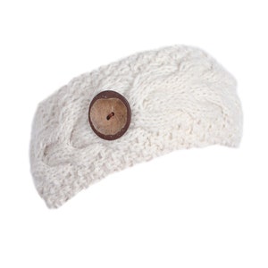 May include: A white knitted headband with a brown button.